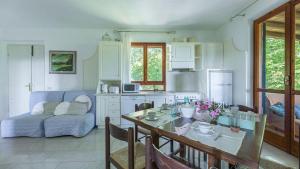 Una cocina y una sala de estar con una mesa y un sofá. en Dalia, en Sassetta