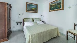 Un dormitorio con una cama en una habitación blanca. en Gardenia, en Sassetta