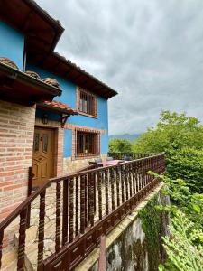 a house with a wooden balcony with a blue at La Casa Grande de Cabrales II in Canales