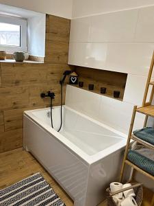 a white bath tub in a room with wooden walls at Na Gruntě in Škvořetice +21 photos