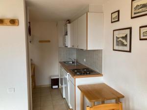 a small kitchen with white cabinets and a sink at Duplex cosy à Termignon-Val Cenis, 7 pers, au pied des pistes, balcon, garage, Wi-Fi gratuit - FR-1-508-295 in Termignon