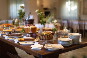 a long table with cakes and plates of food at Hotel Massimo in Marina di Cecina