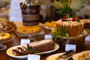 a table filled with different types of cakes and pastries at Hotel Massimo in Marina di Cecina