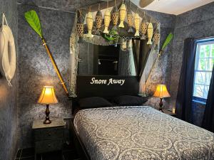 a bedroom with a canopy bed with a mirror at Belize Budget Suites in San Pedro