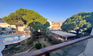 un balcon avec une piscine et des arbres et un bâtiment dans l'établissement L'appart B42, à Gruissan