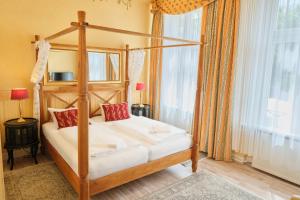 a bedroom with a canopy bed in a room at Anno 1900 Hotel Babelsberg in Potsdam