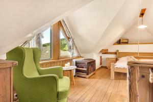 a room with a green chair in a attic at Chalet Vitranc in Kranjska Gora