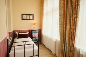 a bedroom with a bed and a dresser and a window at Anno 1900 Hotel Babelsberg in Potsdam