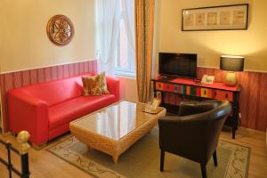 a living room with a red couch and a table at Anno 1900 Hotel Babelsberg in Potsdam