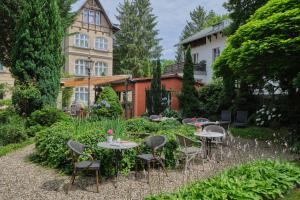 a garden with tables and chairs in front of a building at Anno 1900 Hotel Babelsberg in Potsdam