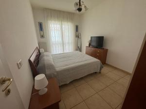 una piccola camera da letto con un letto e una televisione di Da Zia Rosa a Vasto