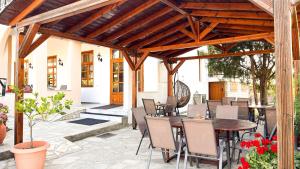 a patio with a wooden pergola with a table and chairs at Philoxenia Hotel in Skala Prinou +33 photos