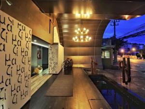 a building with a swimming pool and a chandelier at Mazi Design Hotel by Kalima - SHA Plus in Patong Beach