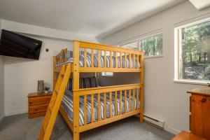 a wooden bunk bed in a room with a television at Spacious Home in an Amazing Location by Harmony Whistler in Whistler