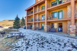 un edificio con bancos frente a él en la nieve en Near Skiing Studio with Pool Access in Granby!, en Granby