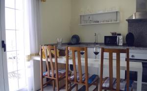 une cuisine avec une table et deux chaises ainsi qu'une table avec des verres à vin dans l'établissement Casa del Sol y la Luna Apartamento Atardecer, à Tíjola