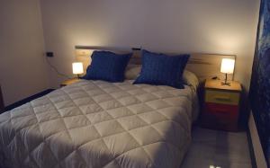 - une chambre avec un lit doté d'oreillers bleus et de 2 lampes dans l'établissement Casa del Sol y la Luna Apartamento Atardecer, à Tíjola