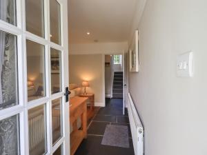 ein Flur mit einer Tür, die zu einem Wohnzimmer führt in der Unterkunft Brook Cottage in Windermere