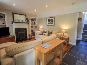 ein Wohnzimmer mit zwei Sofas und einem Kamin in der Unterkunft Brook Cottage in Windermere