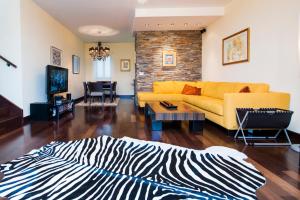 sala de estar con alfombra de cebra y sofá amarillo en Apartment Mia, en Rovinj