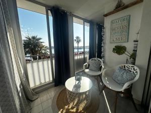 een kamer met 2 stoelen en een tafel met uitzicht op de oceaan bij Appart A l'abordage Sète, Gare, parking in Sète