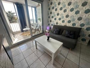 een woonkamer met een bank en een tafel bij Appart A l'abordage Sète, Gare, parking in Sète