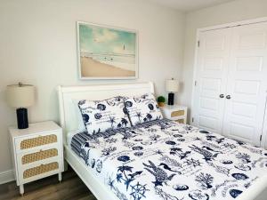 巴拿马城海滩Coastal Dacha的卧室里有一张床，床铺有蓝白相间的被子 更多38张照片