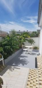a patio with a table and chairs on a balcony at Les Belous in La Rochelle