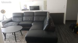 a living room with a black couch and a table at Les Belous in La Rochelle