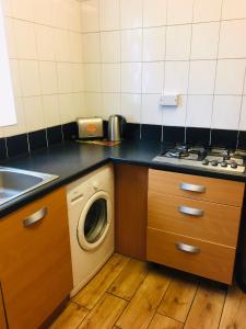 a kitchen with a washing machine and a sink at Hagley Road West House in Birmingham