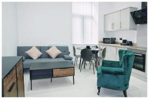 a living room with a blue couch and a table at The Grandeur Mill in Bradford +99 photos