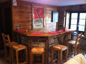 a bar in a room with wooden walls and chairs at Au Chant Des Marmites in Saint-Lary-Soulan