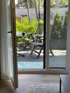 una puerta abierta a un patio con una silla en Apartamenty na wydmach RB, en Międzywodzie
