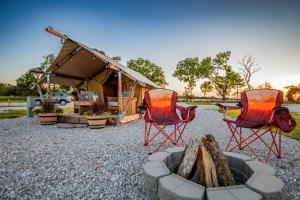 two chairs and a fire pit in front of a tent at Roaring River Luxury Adventure Tent #12 in Cassville