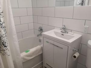 a white bathroom with a sink and a bath tub at Almo Court Motel in Cranbrook +72 photos