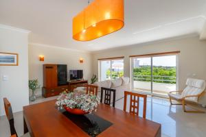 a living room with a dining room table with a vase of flowers at Close to the sea, to Lisbon and to your heart in Silveira