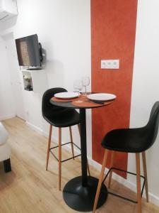 - une petite table avec 2 chaises et des verres à vin dans l'établissement Le cocon rouennais - Terrasse - Climatisation - Gare, à Rouen