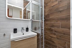 une salle de bain avec un lavabo et un miroir dans l'établissement Le cocon rouennais - Terrasse - Climatisation - Gare, à Rouen 2 autres photos
