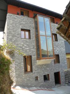 una casa con ventanas de cristal en un lateral en Casa Do Ferreiro - La Fragua en Las Herrerías