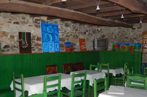 comedor con sillas y mesas verdes y TV en Casa Do Ferreiro - La Fragua, en Las Herrerías