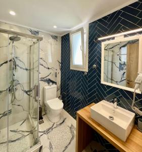 a bathroom with a toilet and a sink and a shower at Irini Seaside Luxury Apartments in Mourteri