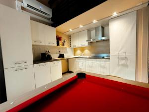 a red pool in a kitchen with white cabinets at Capsule Lotus-Balneo-Sauna-Billard-Nintendo in Hastière-par-delà