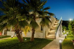 een huis met palmbomen ervoor bij Aqua Sea Relais, Luxury Apartment & Pool in Vieste