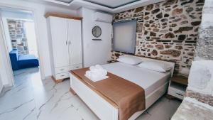 a bedroom with a bed and a stone wall at Evaggelia's Stone Suites in Skala Marion