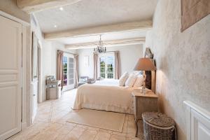 ein Schlafzimmer mit einem Bett und einem Tisch mit einer Lampe in der Unterkunft Mas provencal luxueux vue mer in Mougins