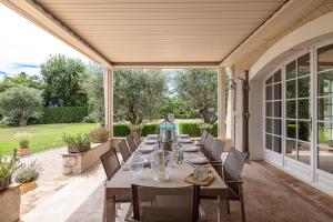 eine Terrasse mit einem langen Tisch und Stühlen in der Unterkunft Mas provencal luxueux vue mer in Mougins