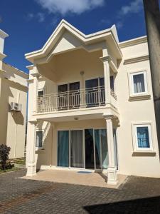 GoodlandsにあるQBM Bungalowのバルコニー付きの大きな白い家