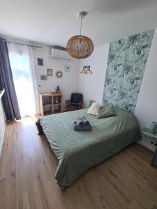 a bedroom with a bed with a green comforter at Le Petit Chêne in Orgnac-lʼAven +38 photos