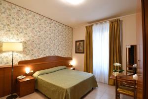 Postel nebo postele na pokoji v ubytování Hotel Innocenti + 23 fotografií