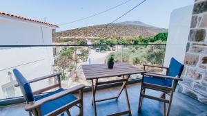 a table and chairs on a balcony with a view at Evaggelia's Stone Suites in Skala Marion +22 photos